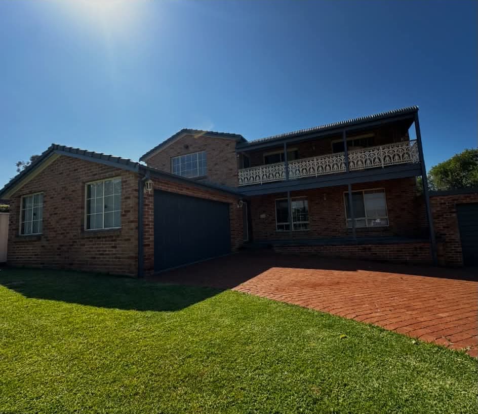 The same home with garage door, gutters, eaves, balcony and posts repainted charcoal